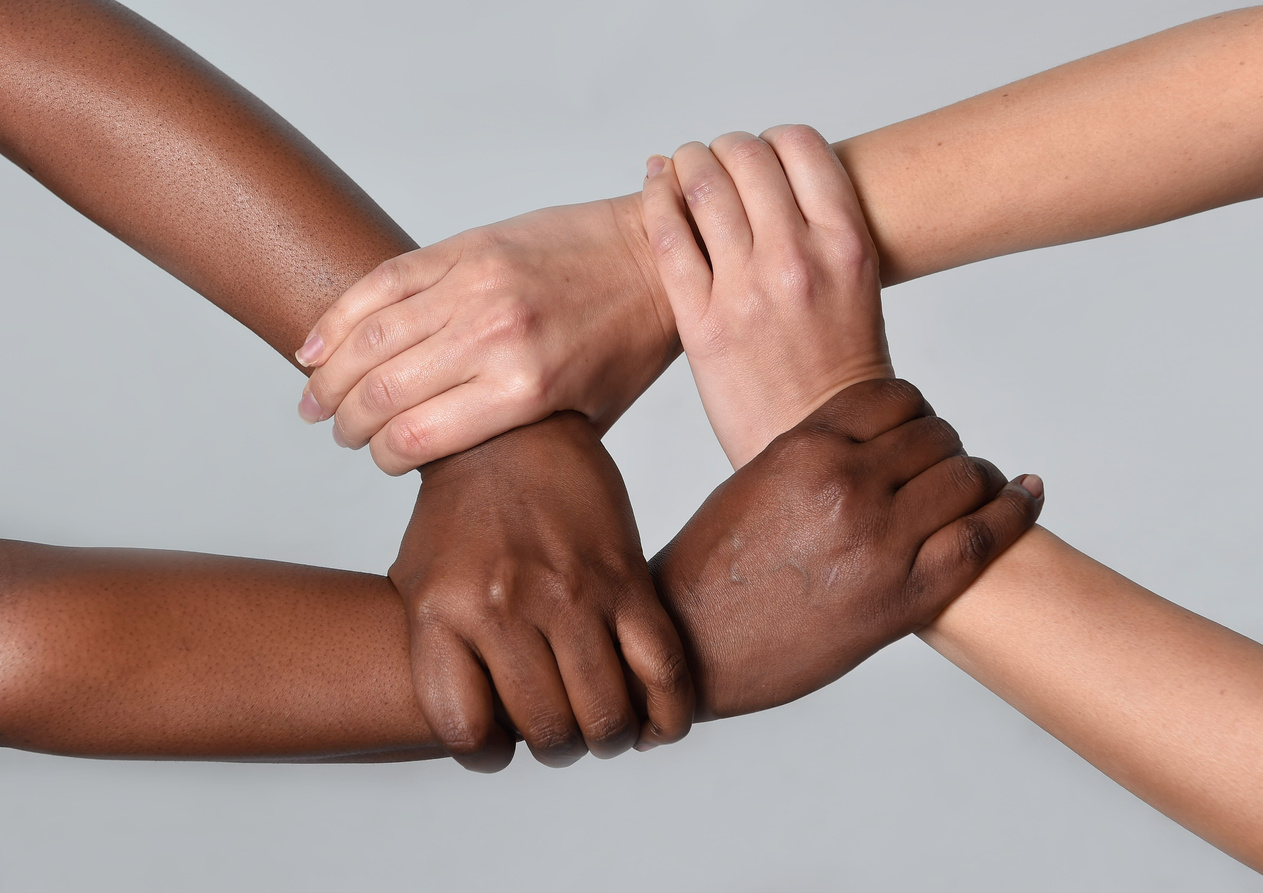 white Caucasian female and black African American hands holding together